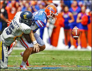 Florida QB Jeff Driskel fumbles as he is hit by Toledo defensive end Jayrone Elliott. The Gators fumbled twice and lost one ball.