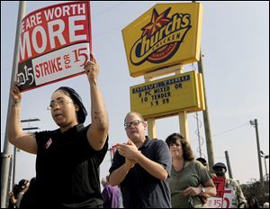 Taco Bell employee Shanise Stitt, left, pickets with other protestors in front of the Church's Chicken fast food restaurant Thursday in Detroit.