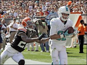 Miami Dolphins wide receiver Brian Hartline, right, catches a 34-yard touchdown pass against Cleveland Browns cornerback Buster Skrine.