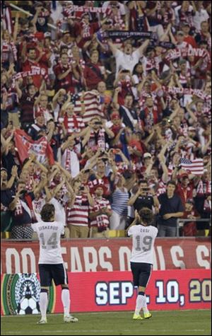 United States' Mix Diskerud, left, and Graham Zusi celebrate the team's 2-0 win over Mexico with fans in Columbus.