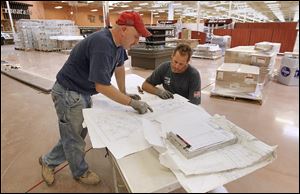 Electricians Jason Pietrowski, left, and Scott Koelsch look over blueprints for installing kitchen equipment in the new Kroger in Maumee. Kroger also plans a new Marketplace store next year on Airport Highway at Holloway Road.