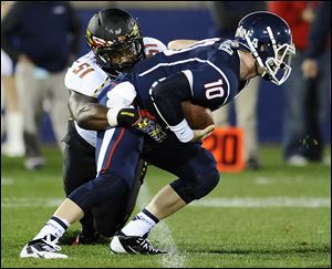 Maryland linebacker Yannik Cudjoe-Virgil (51) sacks Connecticut quarterback Chandler Whitmer (10) during the first half of an NCAA college football game at Rentschler Field, Saturday, Sept. 14, 2013.