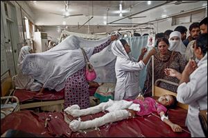 A Pakistani girl who was injured in a suicide attack on a church lies in a hospital bed surrounded by relatives and nurses. The twin suicide bomb attack killed dozens of Christians after worship on Sunday and injured scores. The assault was called the most deadly ever on Pakistan’s Christian minority.