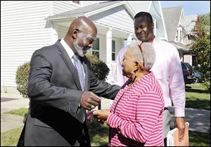 Mayor Mike Bell greets block watch president K. LaVerne Redden as he tours  the London Square/Robinson School neighborhood. Charles Turnbough, the city's neighborhood development specialist, right, looks on.