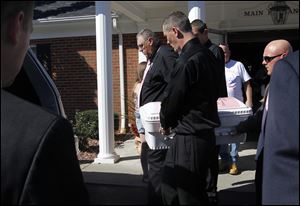 Terry Steinfurth Sr., grandfather of Elaina Steinfurth, and her father Terry Steinfurth Jr., right front, carry Elaina's casket to the hearse at the Eggleston Meinert & Pavley Funeral Home in Oregon, Ohio.