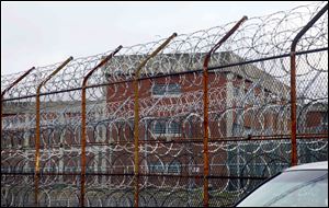 Inmate housing on New York's Rikers Island correctional facility can be seen on the other side of a fence topped with razor wire. The Independent Budget Office found it cost $167,731 in 2012 to house 12,287 daily New York City inmates, which is about $460-per-inmate-per-day. 