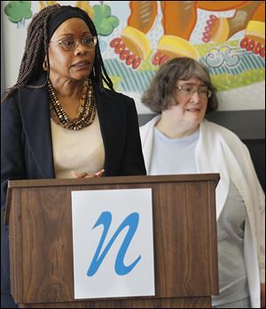 Doni Miller, chief executive with the Neighborhood Health Association outlines the new national health insurance program. Behind her is Kim Kensler, who hopes to obtain insurance.