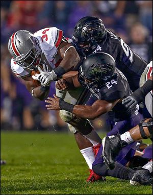 OSU's Carlos Hyde, who had 168 yards rushing, is tackled by Northwestern's Dean Lowry, top, and Ibraheim Campbell.