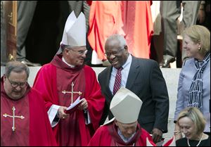 Supreme Court Justice Clarence Thomas talks with clergy following the Red Mass at the Cathedral of St. Matthew the Apostle in Washington. The Supreme Court’s new term starts today.