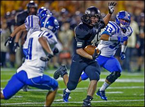 Perrysburg’s Mark Delas cuts between AW defenders Josh Schwerer, left, and Blake Alberts, right, during his 151-yard night.