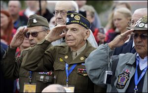 World War II 10th Mountain Division veteran, Charles W. Smith, center, from Plattsburgh, N.Y., salutes with others, during the singing of the National Anthem at the WWII Memorial today in Washington. Four busloads of people, including 43 WWII veterans from the 10th Mountain Division, came to the WWII memorial. The memorial has been closed due to the government shutdown.