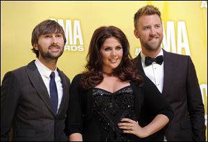 The band Lady Antebellum has postponed a planned November visit to Toledo. Band members are, from left, Dave Haywood, Hillary Scott, and Charles Kelley.