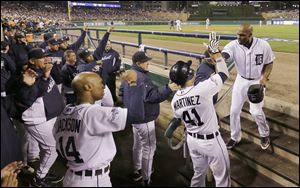 Tigers outfielder Torii Hunter, right, is greeted by Victor Martinez after scoring Miguel Cabrera’s single in the second inning during Game 4 of the ALCS on Wednesday in Detroit. Hunter earlier reached on a two-run double, part of a five-run inning.