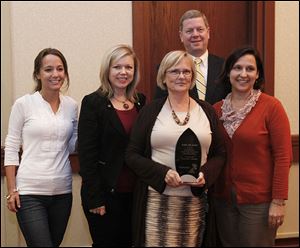 The winning Root Inc. team is made up of Laura Drouillard, left, Michelle Prand, Alma MacDougall, and Kristen Fritz. Behind them is Steve Dolley, chairman of Read for Literacy, which is the beneficiary of the spelling bee.