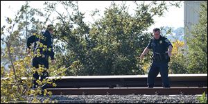 Two BART police officers look over the BART tracks along Jones Road in Walnut Creek, where two workers were killed by a moving BART train in Walnut Creek, Calif. today.