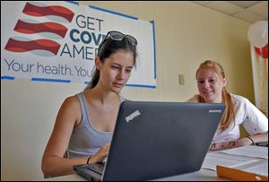 Ashley Hentze, left, of Lakeland, Fla., gets help signing up for Affordable Care Act insurance from Kristen Nash, a volunteer with Enroll America in Tampa.