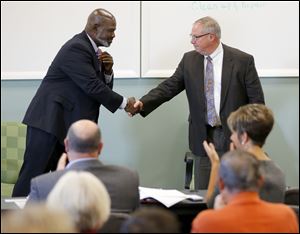 Toledo mayor Mike Bell and mayoral candidate D. Michael Collins shake hands after speaking at Cleaner & Dryer Restoration, Saturday, October 19, 2013.