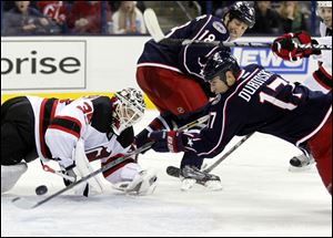 Columbus Blue Jackets' Brandon Dubinsky, right, scores against New Jersey Devils goalie Cory Schneider during the second period.