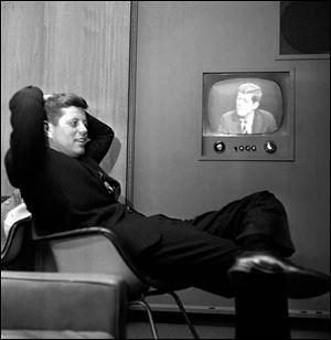 In this April 3, 1960 file photo, Sen. John F. Kennedy, Democratic presidential nominee, sits next to a playback of his televised appearance in Milwaukee, Wis. for the Wisconsin presidential primary two days later. 