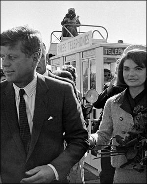 President John F. Kennedy and his wife, Jacqueline Kennedy, arrive at Love Field airport in Dallas, as a television camera, above, follows them. 