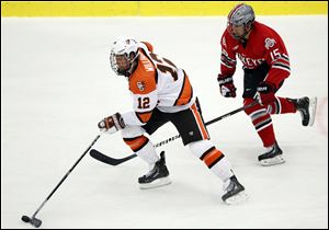 Bowling Green State University's Bryce Williamson (12) moves the puck against  against Ohio State's Nick Oddo (15)  during a hockey game Oct. 15, 2013, in Bowling Green, Ohio.