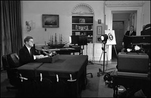 U.S. President John F. Kennedy addresses the nation by television and radio from the Oval Office in Washington, announcing a U.S. naval blockade of Cuba.