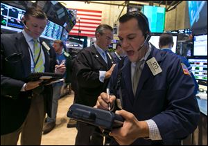 Trader Michael Zicchinolfi, right, works on the floor of the New York Stock Exchange today.