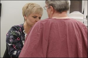 Jenny Kulish, left, performs a mammogram for breast cancer survivor Margery Doncouse in the Breast Care Center at Toledo Hospital in the Harris McIntosh Tower.