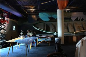 Lead builder John Daugs, left, works on an exhibit instillation near a 160 year-old boat.