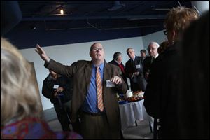 Chris Gillcrist executive director of the Great Lakes Historical Society, directs the group of more than 50 people who had come to tour the partially renovated National Museum of the Great Lakes near downtown Toledo.