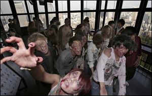 Participants wearing zombie makeups perform during a Halloween event at Tokyo Tower.