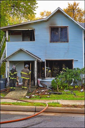 Firefighters knock down areas of a smoldering wall at 458 Fassett St. in East Toledo. The fire broke out Saturday and crews were called about 1:17 p.m., officials reported.