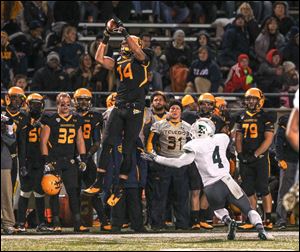 UT's Justin Olack goes high to catch a pass against Eastern Michigan's Willie Creear in Saturday night's game. The Rockets improved to 6-3, 4-1 in the Mid-American Conference.