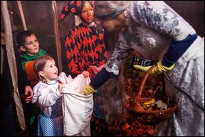 Reese Hartbarger, 5, left, Connor Davis, 7, and Torie Davis, 11, get candy from the spooky ‘Bloody Bride,’ Michelle Atkinson, on Weldwood Lane in Sylvania. Or did they really get the cubes of ice?