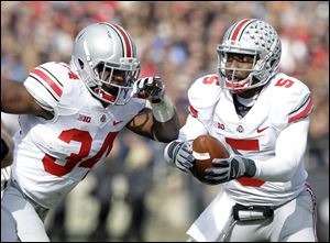 Ohio State quarterback Braxton Miller, right, fakes a handoff to running back Carlos Hyde during the first half Saturday at Purdue in West Lafayette, Ind. The Buckeyes are one of five unbeaten teams from power conferences.