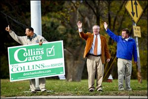 Mayoral candidate D. Michael Collins waves to passing cars along with UAW Local 14 President Ray Wood, left, and Ohio Veterans United state co-chairman Tom Morgan in front of General Motors Co.'s Toledo Transmission plant on Alexis Road. 