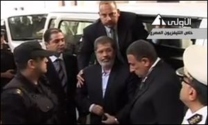 Ousted President Mohammed Morsi arrives for a court hearing at a police academy compound in Cairo, Egypt, today, on Egyptian State Television.