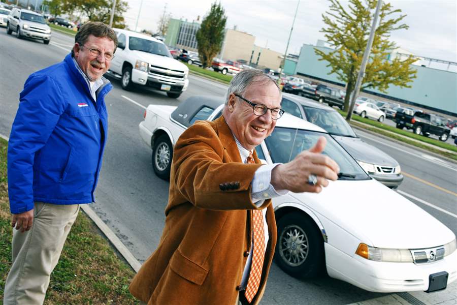 D-Michael-Collins-greets-motorists-in-front-of-Gene