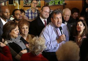 New Mexico Governor Susana Martinez, left, listens along with New Jersey first lady Mary Pat Christie, right, as New Jersey Gov. Chris Christie greets supporters during a campaign stop in Hillside, N.J., Monday.