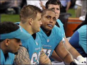 Miami Dolphins guard Richie Incognito (68), center left, and  and tackle Jonathan Martin (71), center right, sit on the bench in the second half of an NFL football game earlier this season.