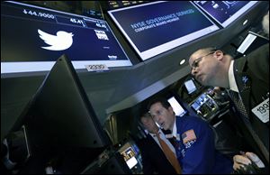 Trader Jeffrey Vazquez, right, and specialist Glenn Carell, center, work at the post that trades Twitter on the floor of the New York Stock Exchange on Friday.