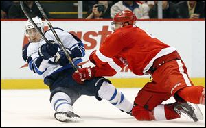 Detroit Red Wings defenseman Jakub Kindl, right, of the Czech Republic, checks Winnipeg Jets center Mark Scheifele, left, during the first period of an NHL hockey game in Detroit, Tuesday, Nov. 12, 2013. (AP Photo/Paul Sancya)