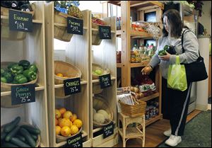 Cindy Thomas of Toledo shops for vegetables at the Flower Market’s Garden Grocer on Monroe Street.