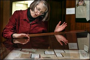 Barbara Floyd, the Ward M. Canaday Center director at the University of Toledo's William S. Carlson Library, looks over a John F. Kennedy exhibit there. 