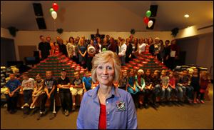 Cheryl Beal, coordinator of Operation Christmas, stands in front of 1,000 shoe boxes and some of the others who made it happen, at Bedford First Church of the Nazarene in the Lambertville area.