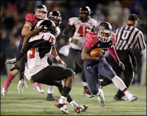 Rockets running back Kareem Hunt tries to get past Jimmie Ward of Northern Illinois. Hunt finished with 91 yards on 19 carries.