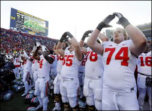 Ohio State University player Jack Mewhort (74) and teammates celebrate their 42-41 win over the University of Michigan in Ann Arbor, Saturday.