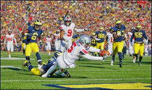 Ohio State quarterback Braxton Miller scores a touchdown as Michigan defensive back Blake Countess tries to stop him.