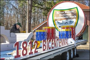 Bill Saul secures chicken wire that will brace artificial snow  on the River Raisin National Battlefield Park’s float for the festival. It has a new trailer, donated by American Manufacturing Operations of Toledo. 