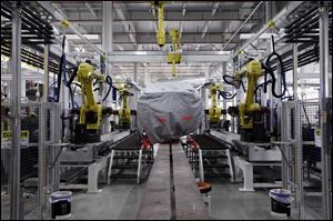 A covered vehicle sits in part of the new paint shop at Chrysler's Sterling Heights Assembly Plant in Sterling Heights, Mich. 